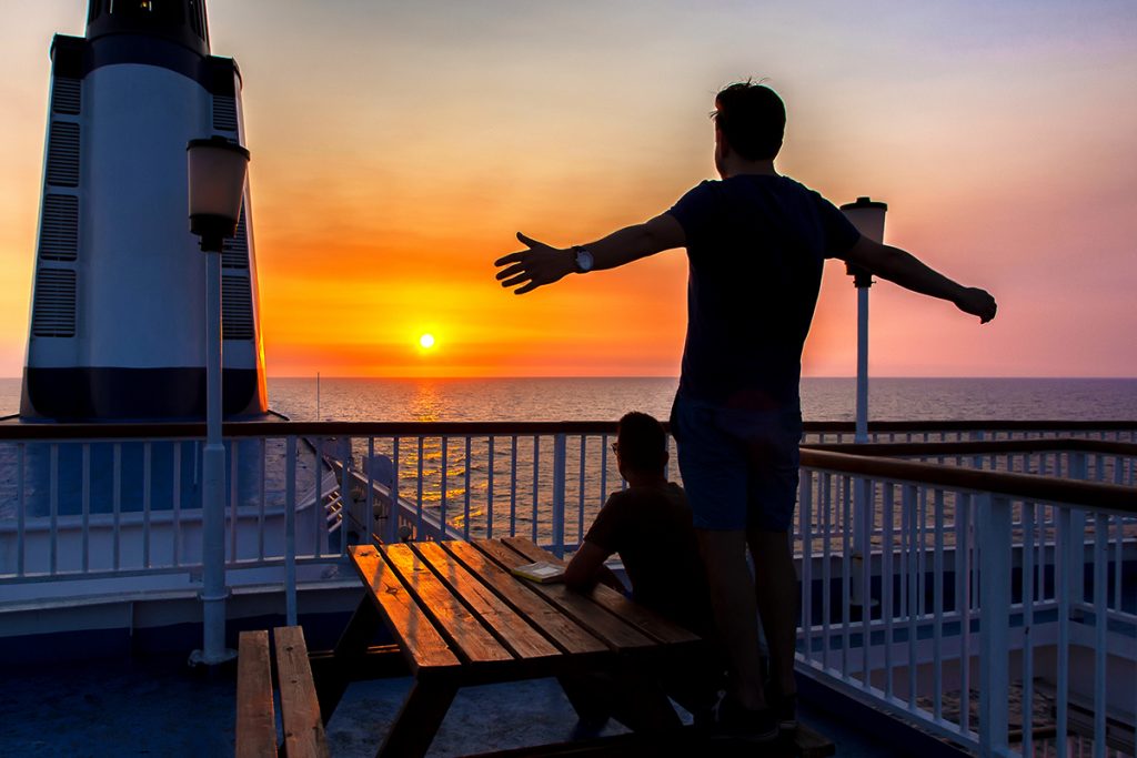 due ragazzi ammirano il tramonto sul ponte della nave, durante il viaggio in Montenegro