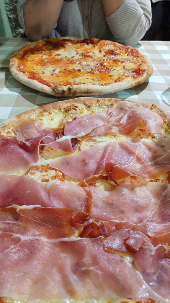 Due pizze su un tavolo in una locanda di Pitigliano, ecco cosa vedere in Maremma