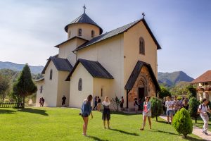 chiesa ripresa di lato con tre ragazzi che cammina davanti, ecco cosa vedere durante le vacanze in montenegro