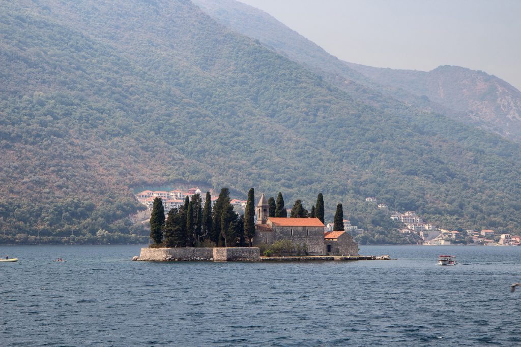 isola di San Giorgio con sopra un'abbazzia benedettina e dei cipressi. vista durante il tour nella baia di Kotor